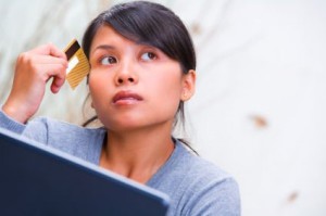 thinking woman with credit card and laptop