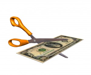 Scissors cutting $100 bill