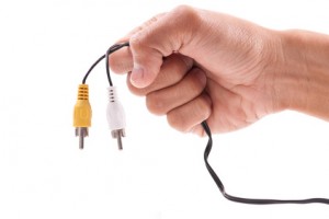 Hand Holding a Yellow and White TV Input Cable