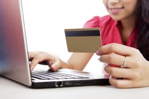 Woman holding credit card with other hand on keyboard of laptop