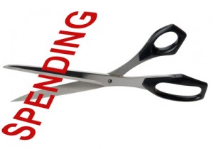 Pair of scissors cutting the word Spending