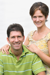 Smiling man and woman facing camera