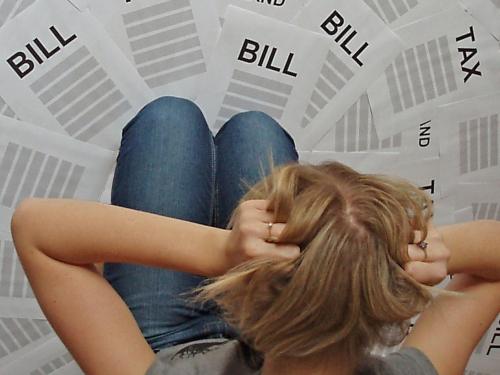 woman kneeling over bills