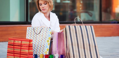 woman sitting down with shopping bags