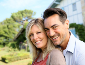mature couple in front of a house
