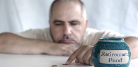 man counting coins next to retirement fund