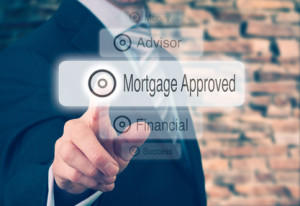 Businessman pressing a Mortgage Loan Approval concept button.