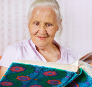 Elderly woman looking at the family photo album