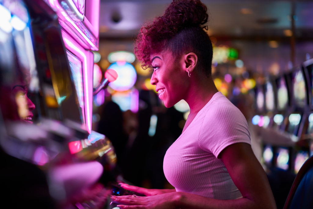 happy woman gambling at a casino slot machine
