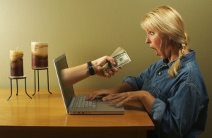 woman being handed money from laptop screen