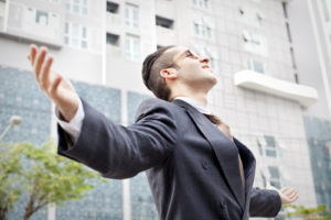 man in business suit with outstretched arms
