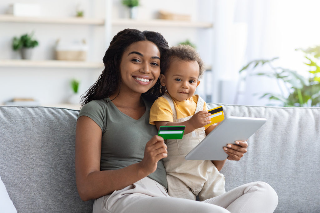 woman holding a baby and a credit card