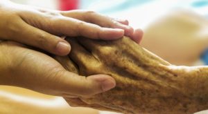 elderly person holding hands e1519828723491
