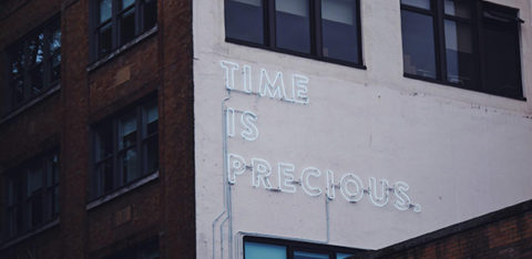 a sign saying "time is precious" on a building