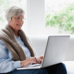 Smiling older woman using laptop
