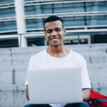 guy with laptop sitting on steps