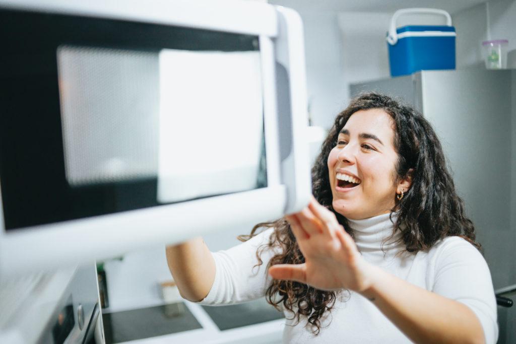 young woman making a microwave mug meal
