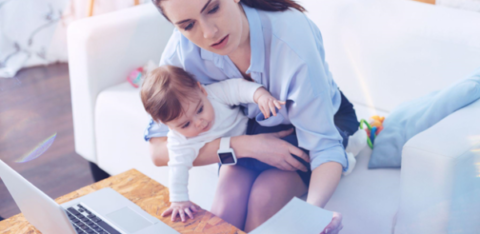 woman looking at credit report while holding a baby