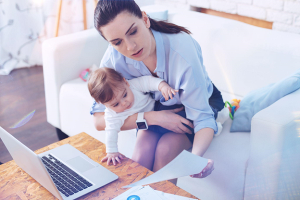 woman looking at credit report while holding a baby