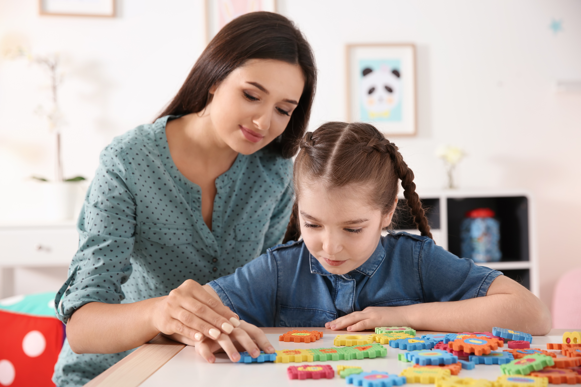 A parent playing with their child, who is autistic, at their home.