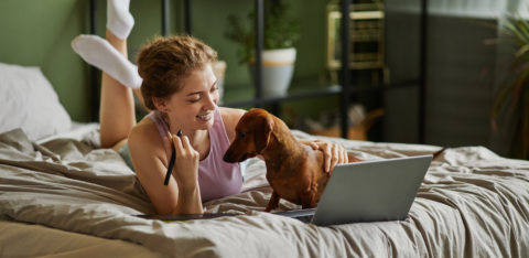 woman on her laptop with her dog