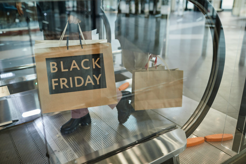 person holding a black Friday shopping bag