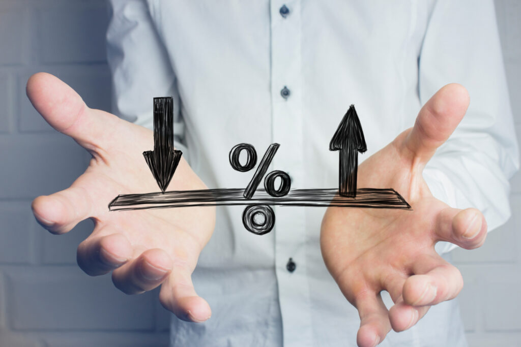 Person holding their hands beneath a percentage symbol with arrows pointing up and down.
