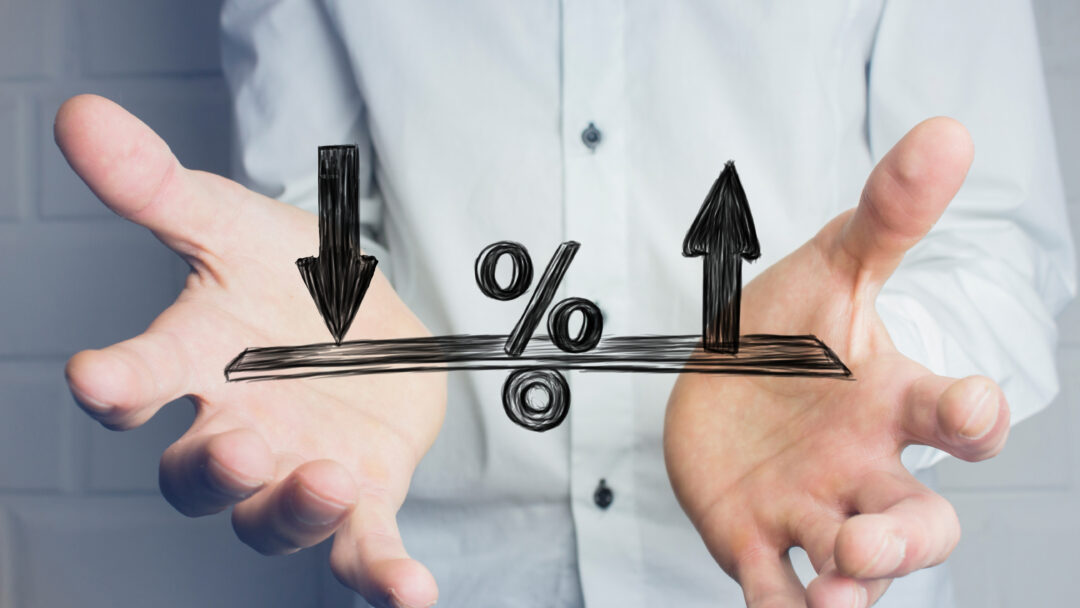 Person holding their hands beneath a percentage symbol with arrows pointing up and down.