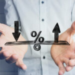 Person holding their hands beneath a percentage symbol with arrows pointing up and down.