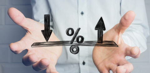 Person holding their hands beneath a percentage symbol with arrows pointing up and down.
