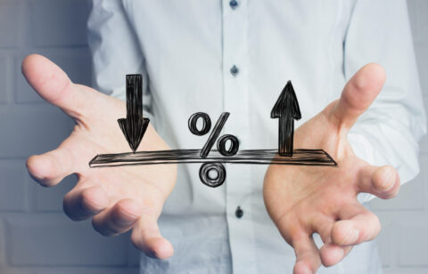 Person holding their hands beneath a percentage symbol with arrows pointing up and down.