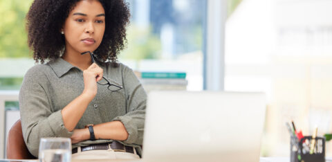 Business laptop, thinking and black woman in office trying to solve problem. Idea, focus and female employee from South Africa with computer contemplating solution, pensive or lost in thoughts alone.