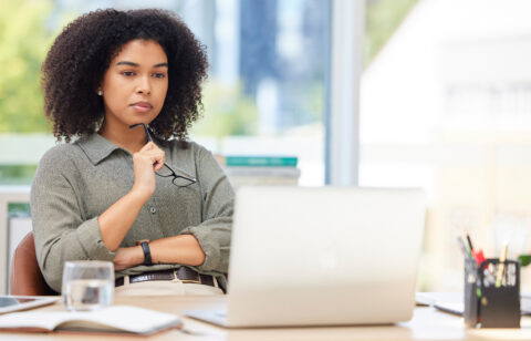 Business laptop, thinking and black woman in office trying to solve problem. Idea, focus and female employee from South Africa with computer contemplating solution, pensive or lost in thoughts alone.