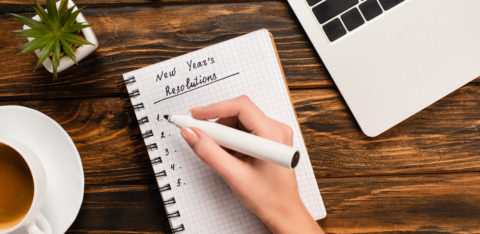 woman writing down financial new year's resolutions