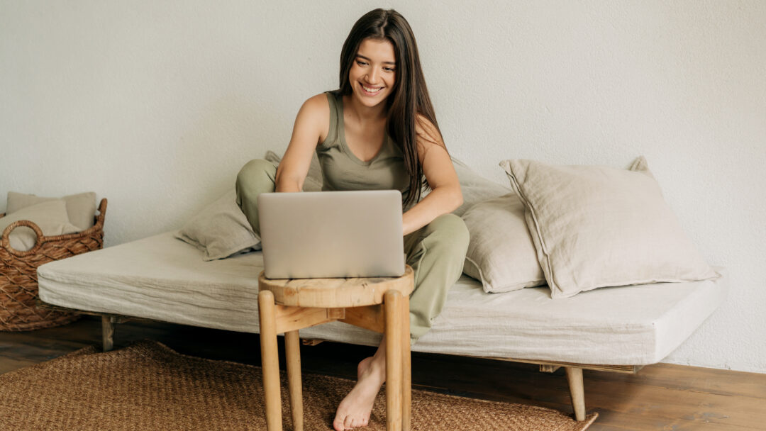 Young happy woman is working at home on a laptop.