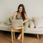 Young happy woman is working at home on a laptop.