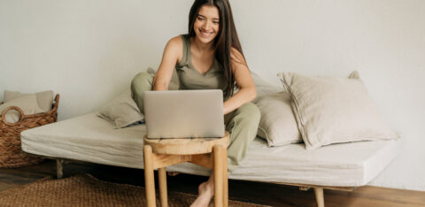 Young happy woman is working at home on a laptop.
