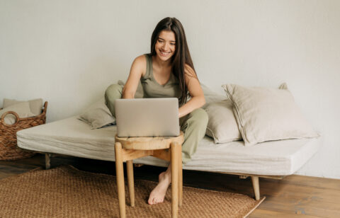 Young happy woman is working at home on a laptop.