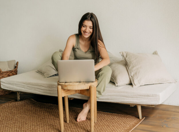 Young happy woman is working at home on a laptop.