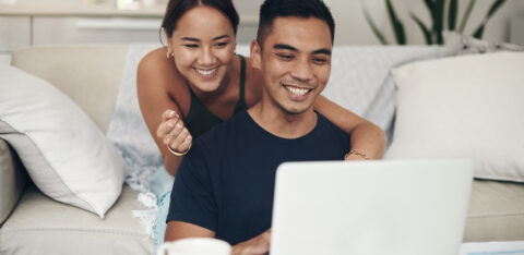 couple smiling and looking at computer