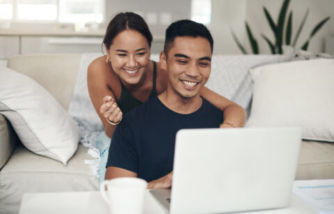 couple smiling and looking at computer