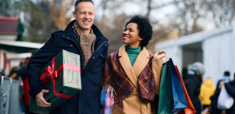 Happy multiracial couple enjoying in Christmas shopping.