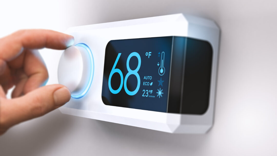 hand turning down temperature for home energy savings