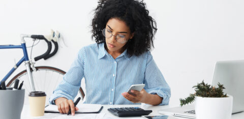 woman filing taxes with calculator and notepad