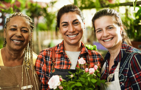 Multiracial senior women working inside greenhouse garden Focus on center female face