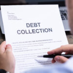 Person holding a debt collection letter while reviewing its contents with a pen in hand.