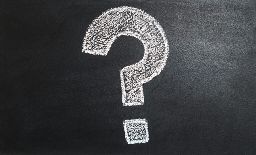 White chalk-drawn question mark on a blackboard background.