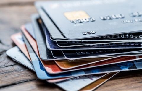 Stack of various credit cards on a wooden surface