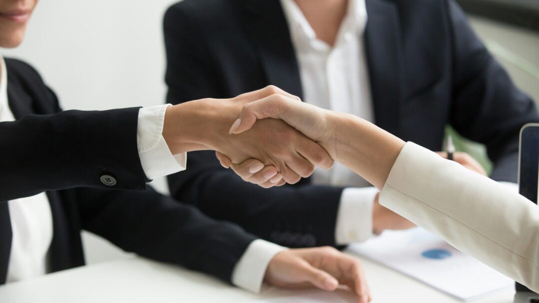 Close-up of a professional handshake between two people in business attire