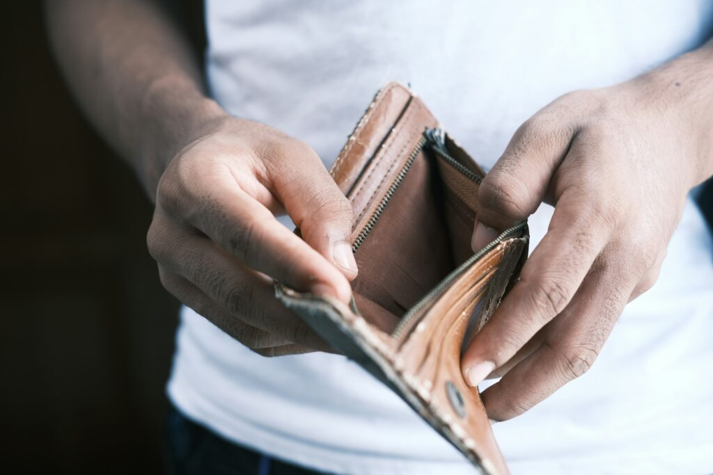 Person holding an open, empty wallet with both hands.